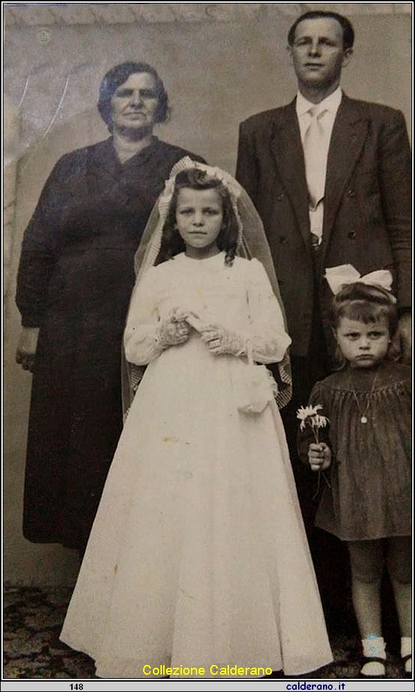 La Prima Comunione di Marisa Glosa con i genitori e la sorellina Pompea.jpg